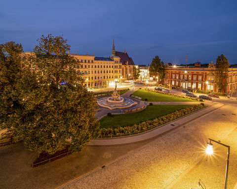 Beleuchteter Postplatz zur Abendzeit mit Muschelminna-Brunnen