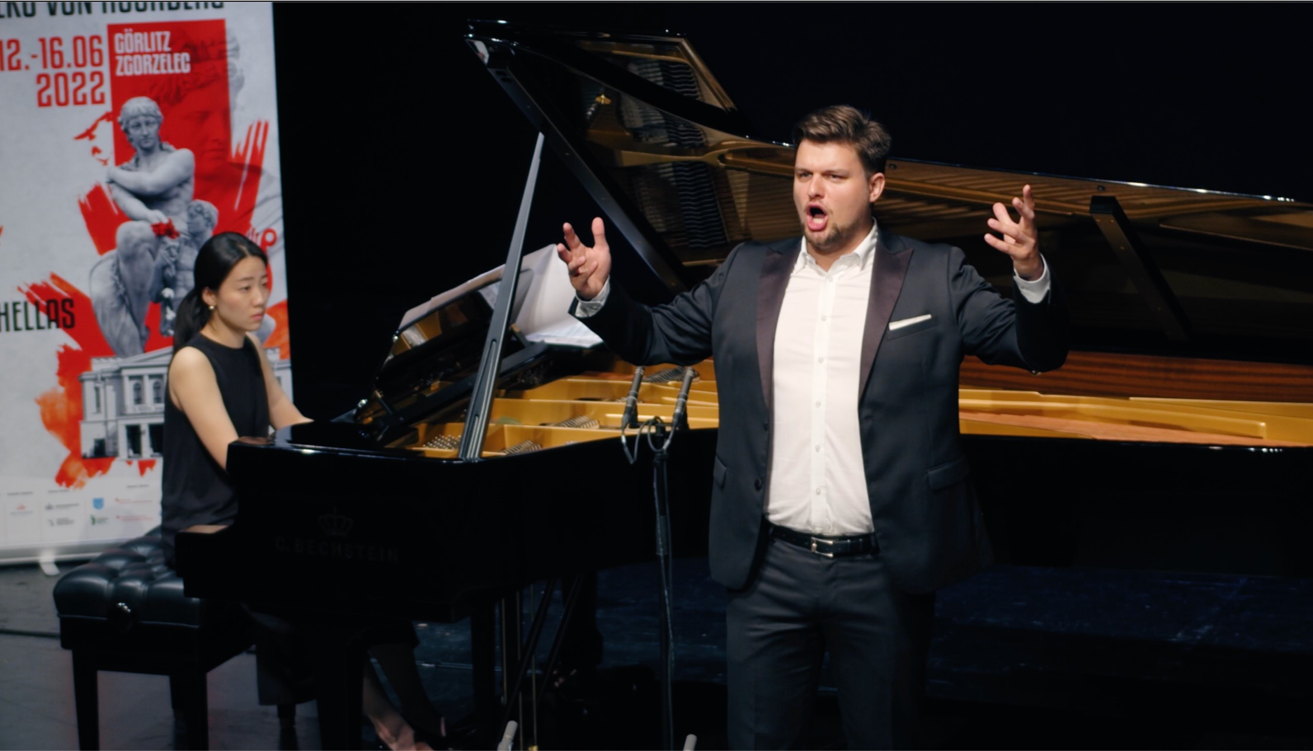 Ein Mann singt vor dem Klavier.